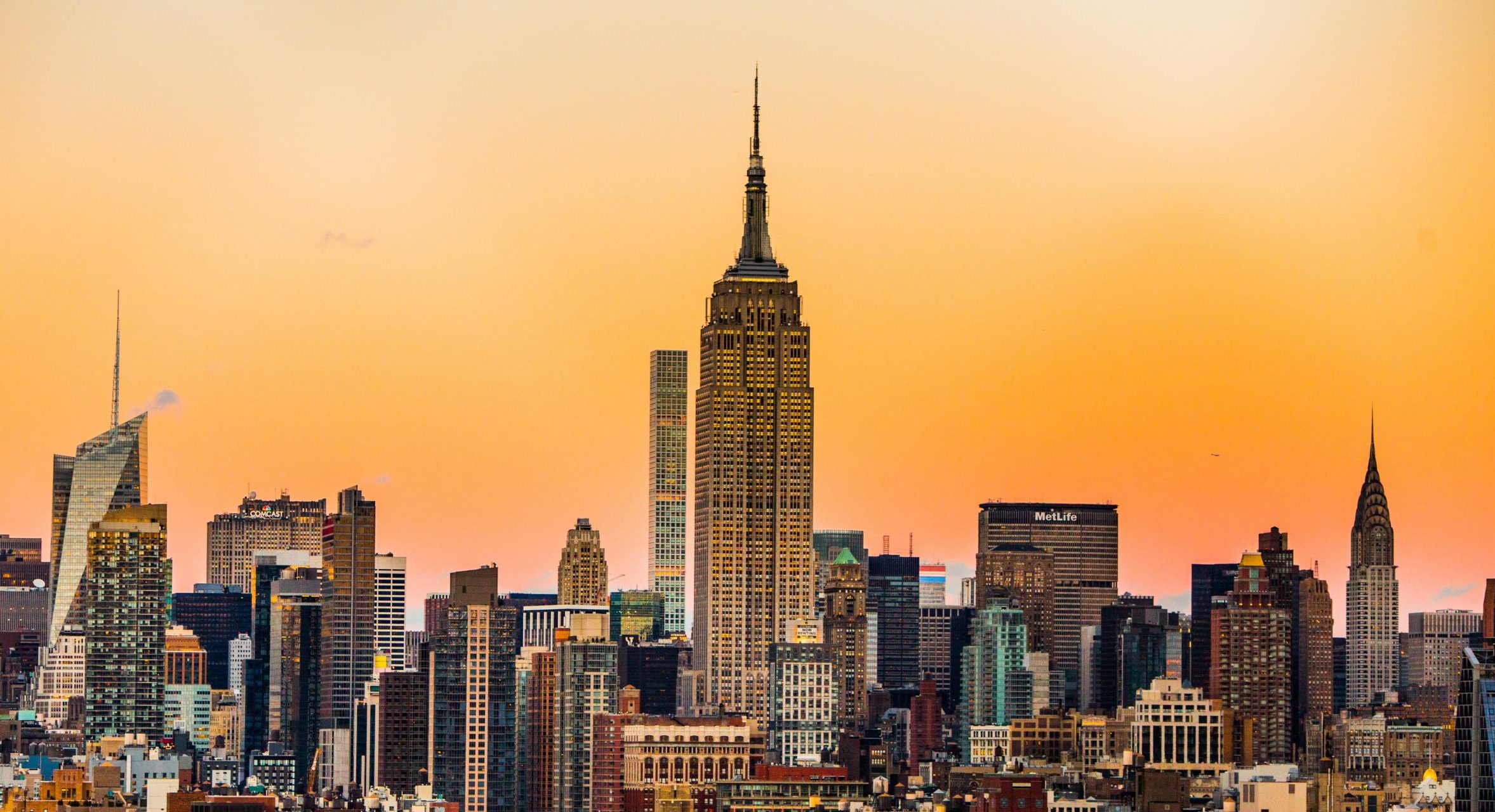 An assortment of iconic New York City foods, including pizza, bagels, and pastrami on rye, showcasing the city's diverse culinary scene.