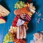 Assorted healthy snacks, including fresh fruit, nuts, and granola bars, displayed on a wooden table. Showcasing the best options for nutritious and delicious snacks in the city.
