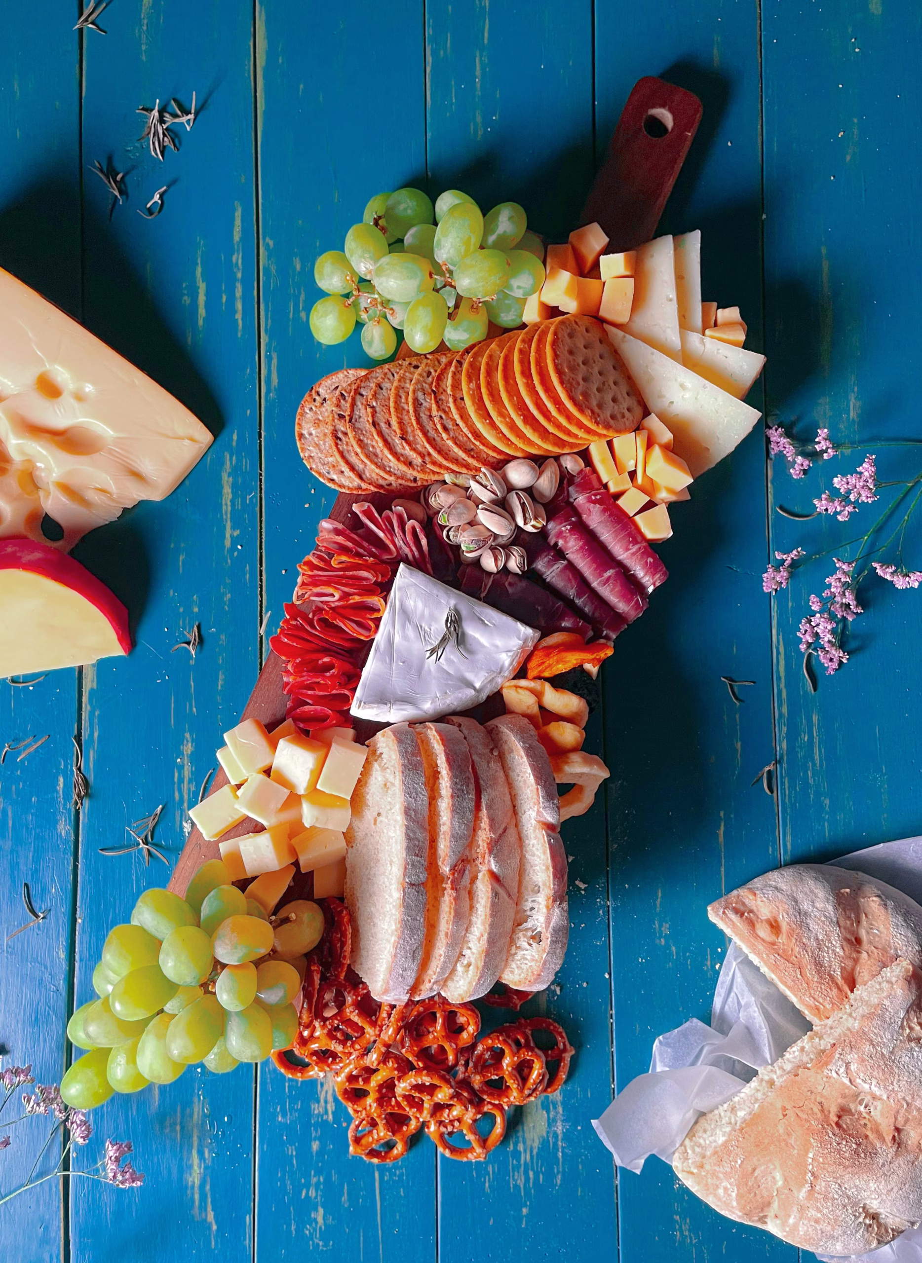 Assorted healthy snacks, including fresh fruit, nuts, and granola bars, displayed on a wooden table. Showcasing the best options for nutritious and delicious snacks in the city.