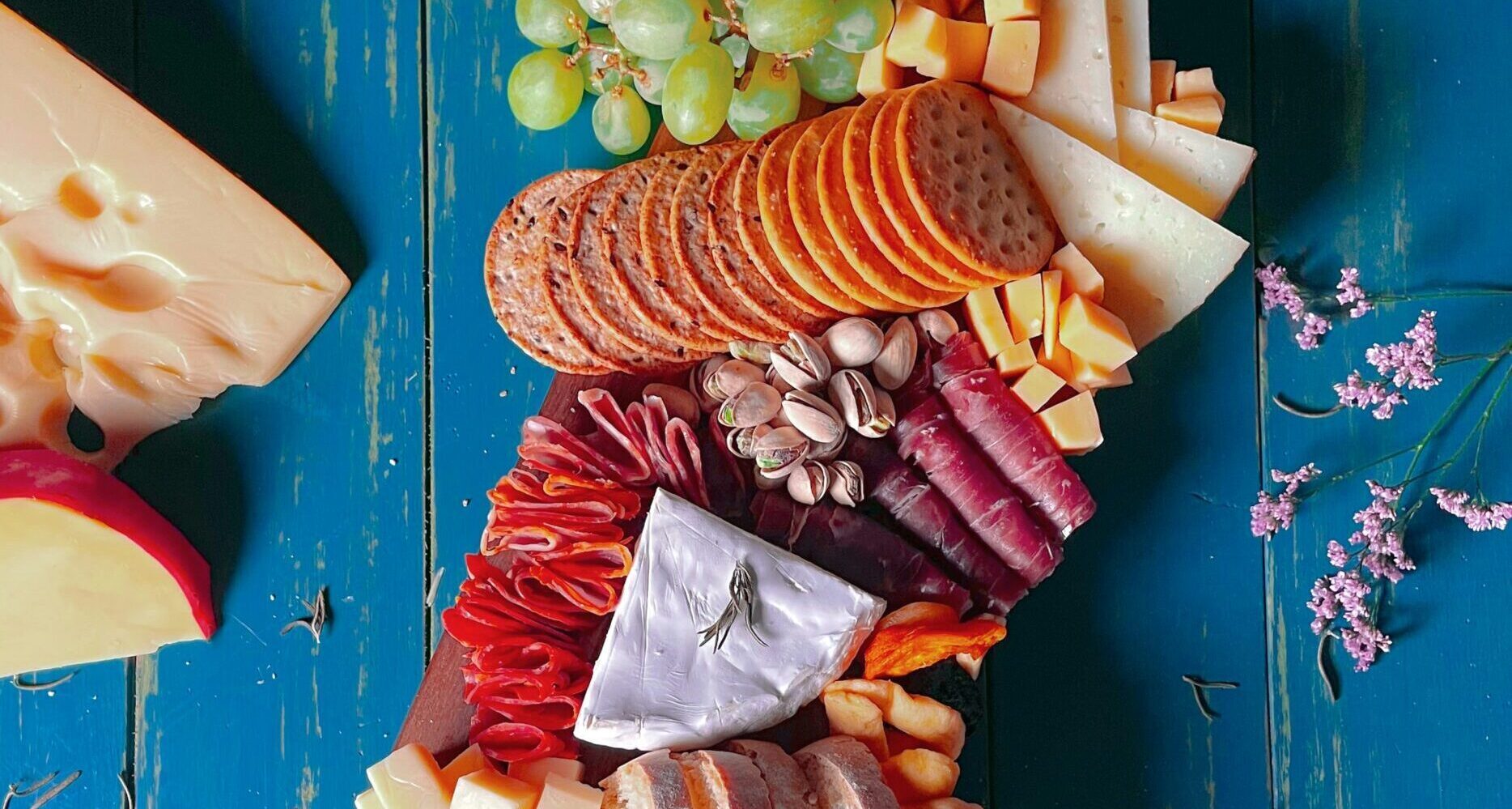 Assorted healthy snacks, including fresh fruit, nuts, and granola bars, displayed on a wooden table. Showcasing the best options for nutritious and delicious snacks in the city.