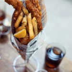 Indulge in a classic British meal with the best fish and chips in coastal towns,