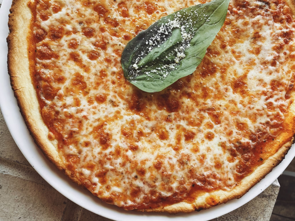 A vibrant pizza night setup with fresh toppings, dough, and baked pizzas, perfect for an easy homemade pizza for birthdays or thoughtful food ideas for celebrations