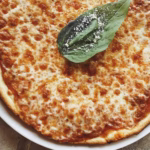 A vibrant pizza night setup with fresh toppings, dough, and baked pizzas, perfect for an easy homemade pizza for birthdays or thoughtful food ideas for celebrations