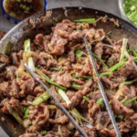 Plated beef bulgogi garnished with sesame seeds and sliced scallions, ready to serve.