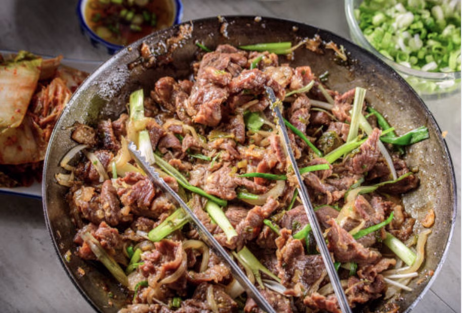 Plated beef bulgogi garnished with sesame seeds and sliced scallions, ready to serve.