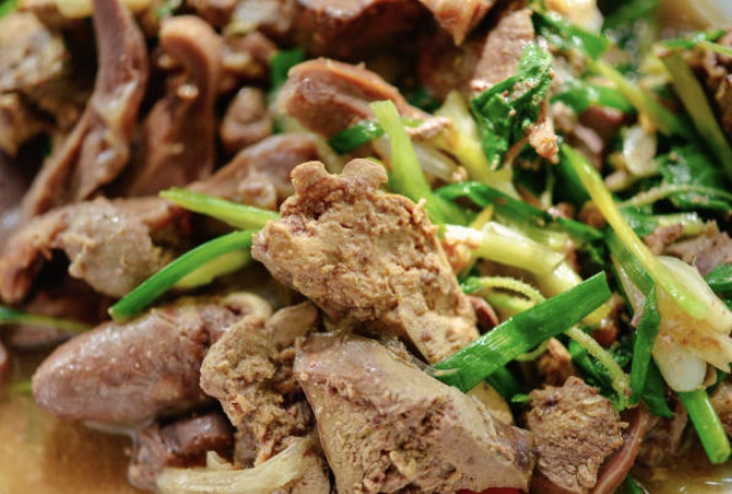 Cooked beef slices being tossed in the thickened bulgogi sauce within a skillet.