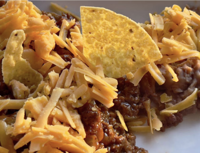 Tex-Mex Army Stew Korean mashup topped with shredded cheddar and crushed tortilla chips