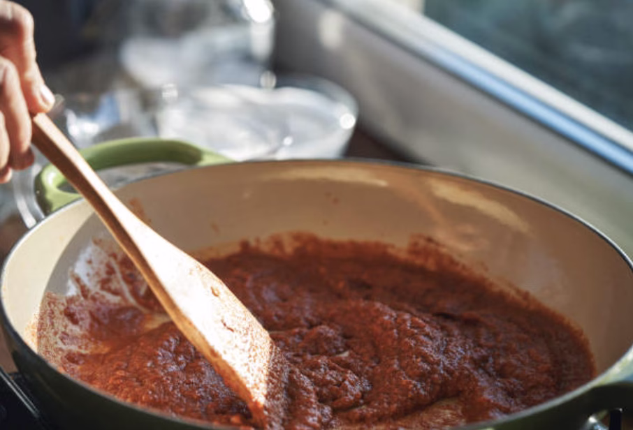 Mixing gochujang and soy sauce in a pan to form the spicy base for rose tteokbokki.