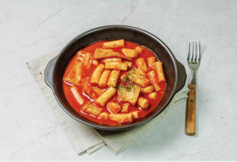 Spicy Rose Tteokbokki with red chili flakes.