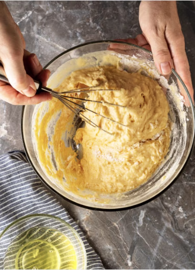 Mixing cornstarch, flour, and spices in a bowl to create the batter for Korean fried chicken.