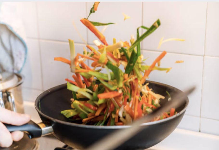 Assorted vegetables sautéed for bibimbap, including spinach, carrots, and mushrooms.