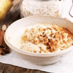 Bowl of oatmeal infused with gochujang, topped with nuts and seeds—a gochujang breakfast idea.
