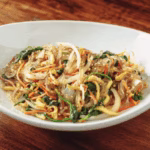 Finished japchae served with sesame seeds and scallions