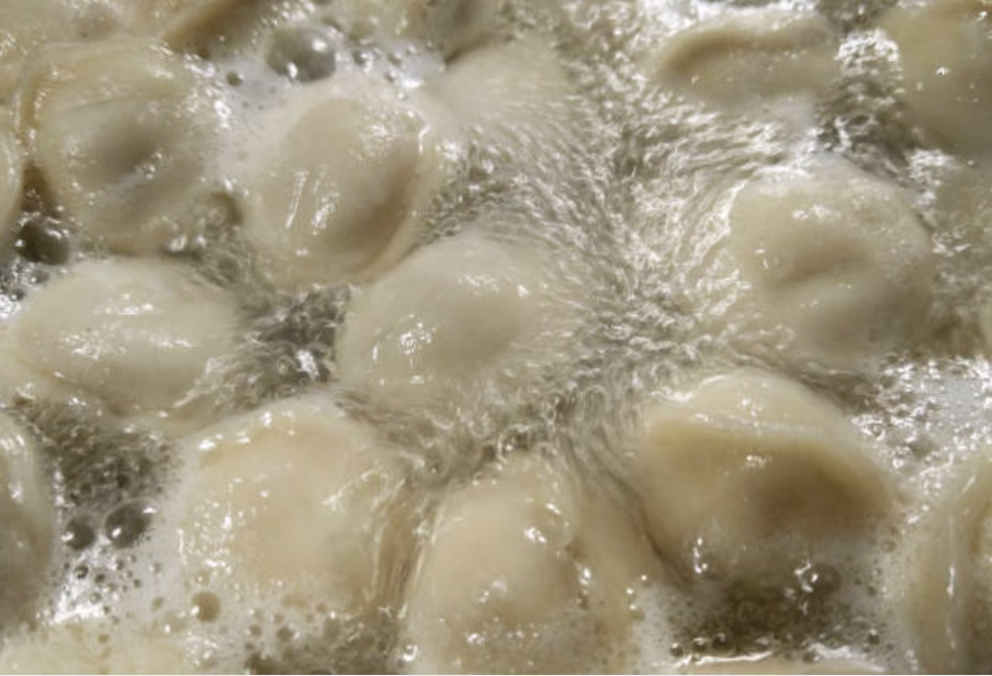 Dropping raw mandu into simmering broth