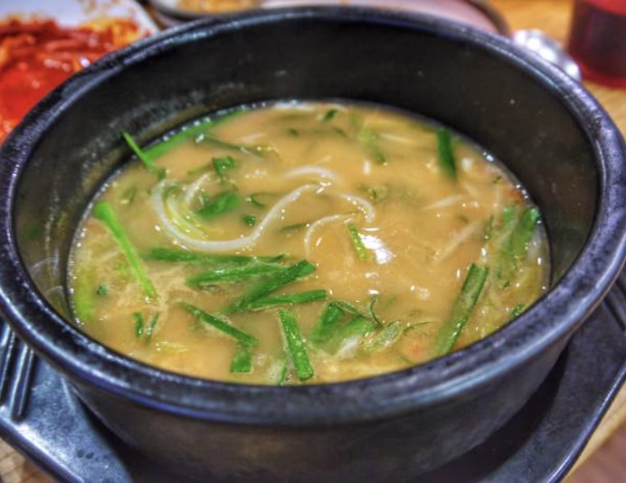 Fresh spinach wilting in hot mandu guk broth